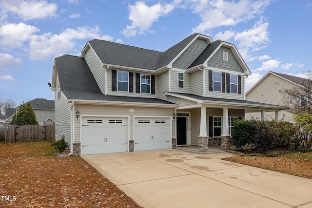 craftsman inspired home featuring fence, concrete driveway, roof with shingles, stone siding, and an attached garage