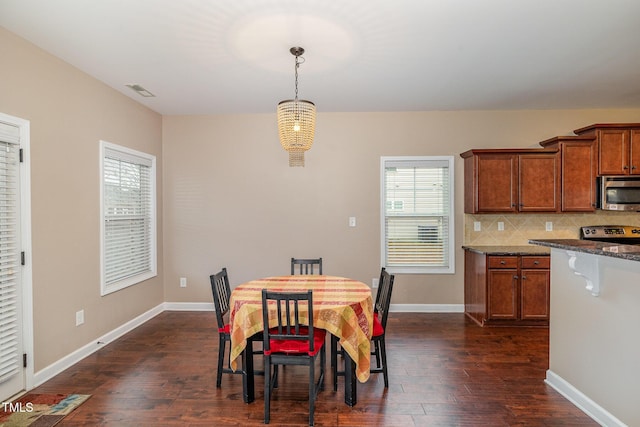 dining area with visible vents, baseboards, and dark wood finished floors