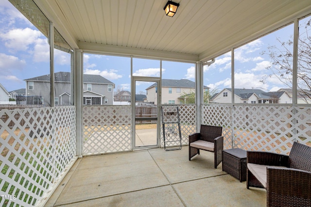 sunroom / solarium featuring a residential view and wood ceiling