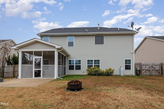 rear view of property with a patio, a yard, a sunroom, a fire pit, and fence private yard