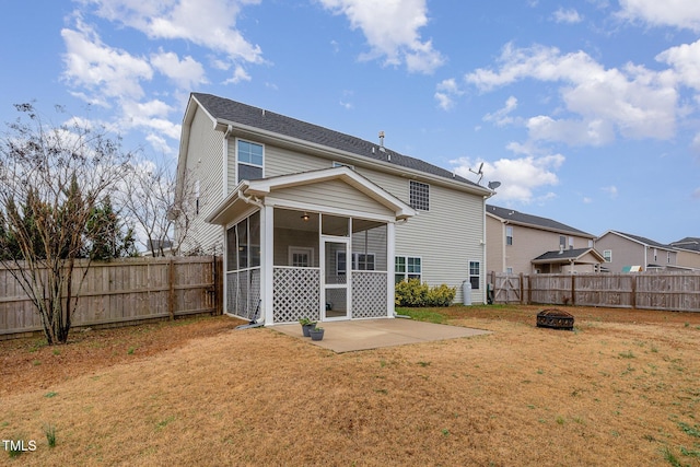 rear view of house featuring a patio area, a lawn, a fenced backyard, and a sunroom