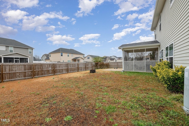 view of yard featuring a fenced backyard, a residential view, and a sunroom