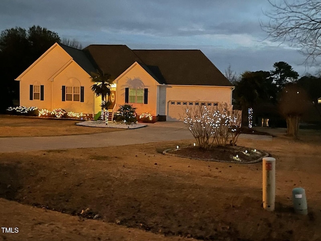 view of front of property featuring brick siding, driveway, and a garage