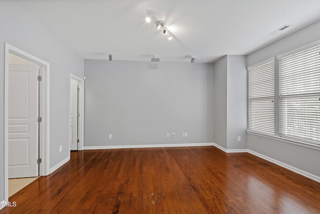 empty room with visible vents, baseboards, and wood finished floors