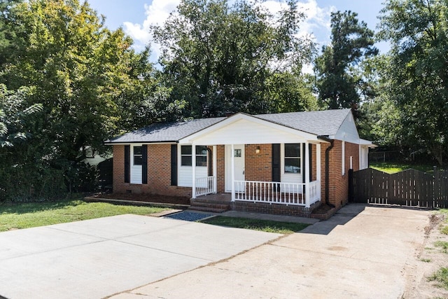 view of front of property featuring a porch, brick siding, driveway, and crawl space