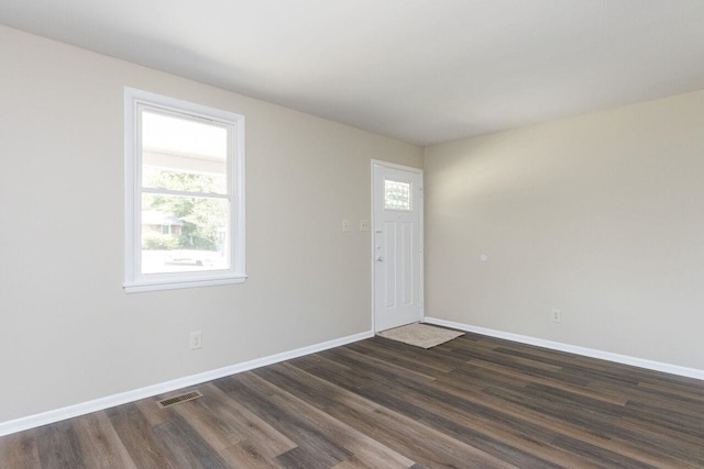 foyer entrance with visible vents, baseboards, and dark wood finished floors