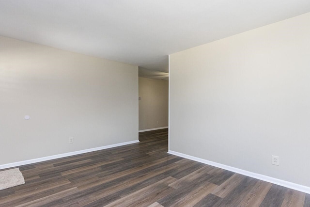 empty room with baseboards and dark wood-style flooring