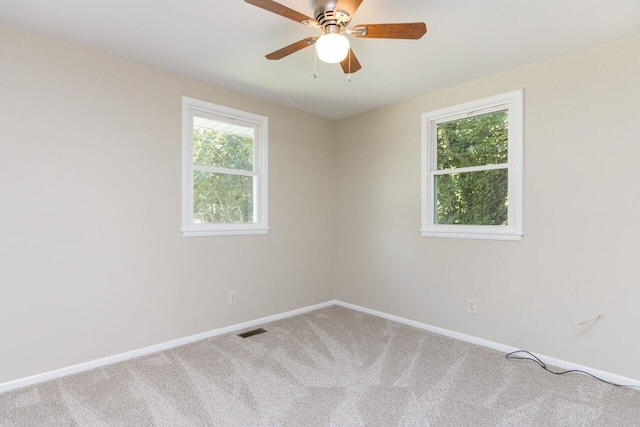 empty room with visible vents, baseboards, a ceiling fan, and carpet flooring