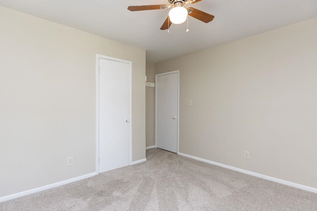 unfurnished room featuring a ceiling fan, baseboards, and light carpet