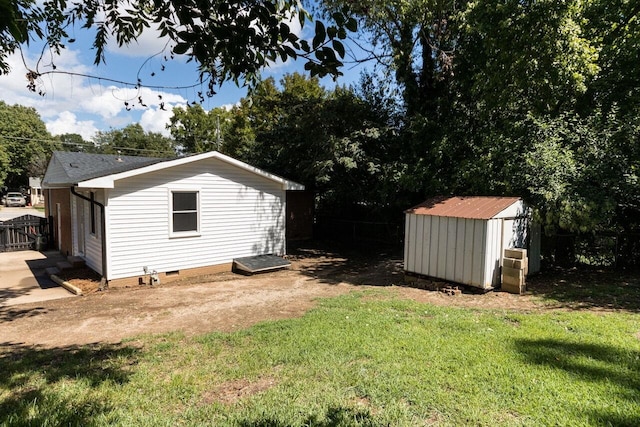 view of yard with an outbuilding, fence, and a shed