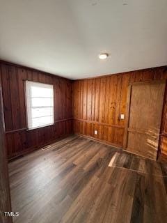 spare room featuring wood walls and wood finished floors