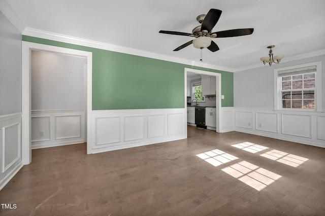 spare room with a sink, wood finished floors, ornamental molding, and ceiling fan with notable chandelier