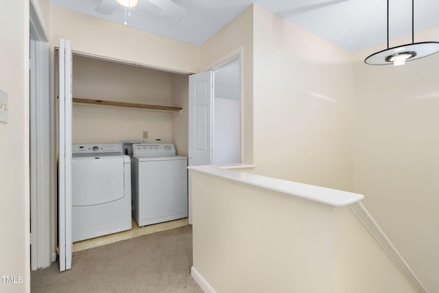 laundry area with baseboards, laundry area, ceiling fan, washer and dryer, and light colored carpet