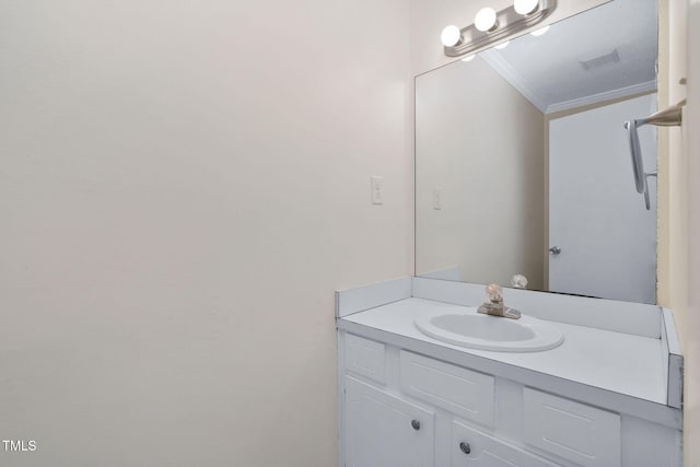 bathroom featuring visible vents, vanity, and ornamental molding