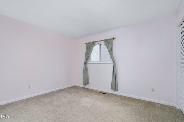 carpeted empty room featuring visible vents and baseboards