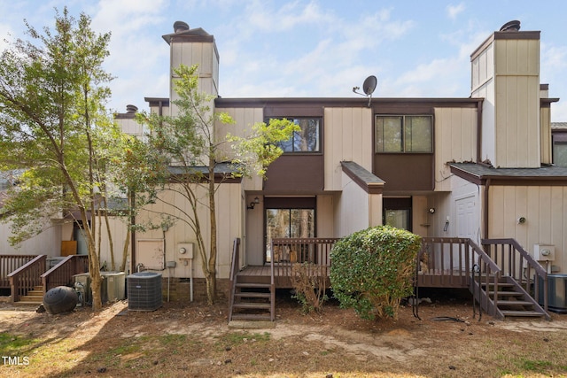 back of property featuring central air condition unit, a deck, and a chimney