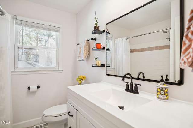 bathroom with vanity, a shower with shower curtain, toilet, and baseboards