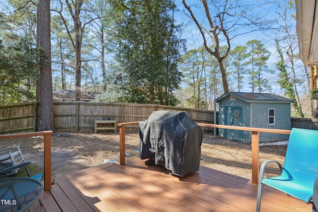 wooden deck featuring a storage unit, an outbuilding, area for grilling, and a fenced backyard