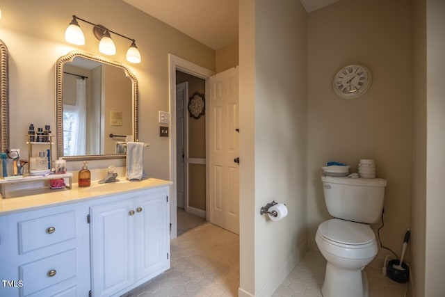 bathroom with tile patterned floors, baseboards, toilet, and vanity