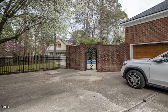 exterior space with driveway, fence, and a gate