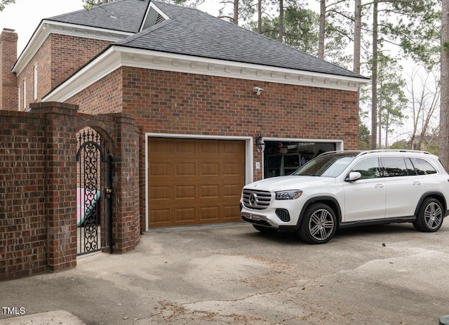 view of side of property featuring brick siding, concrete driveway, and roof with shingles