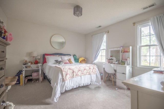 carpeted bedroom featuring multiple windows and visible vents