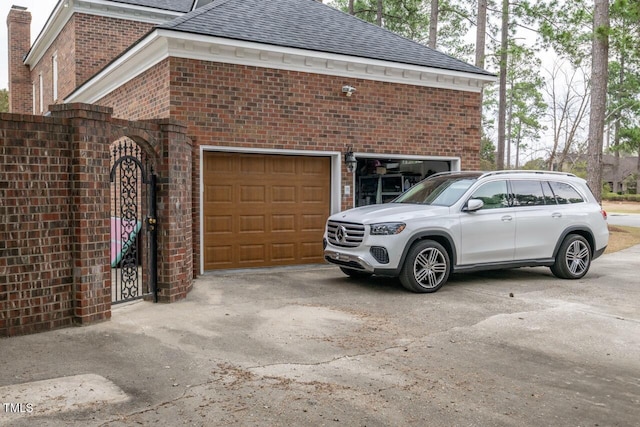 view of home's exterior with brick siding, driveway, and a shingled roof