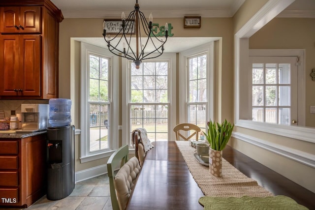 dining area with a wealth of natural light, crown molding, and an inviting chandelier