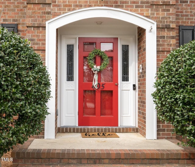 doorway to property with brick siding