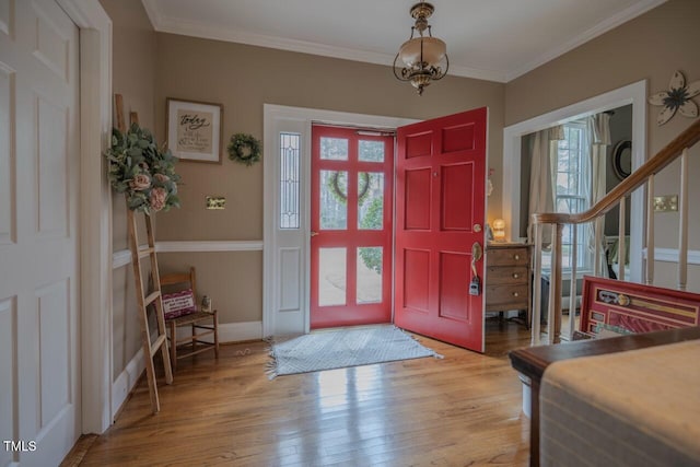 foyer entrance featuring wood finished floors, baseboards, and ornamental molding