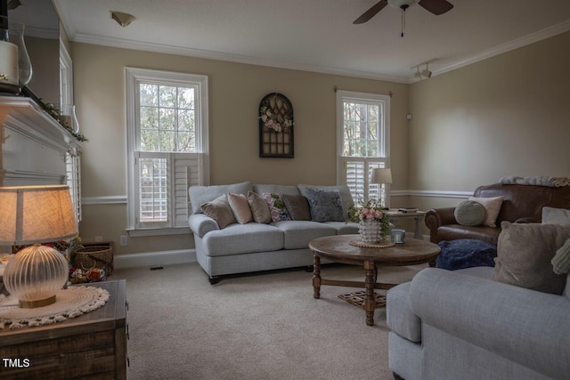 carpeted living room with ceiling fan, baseboards, a healthy amount of sunlight, and ornamental molding