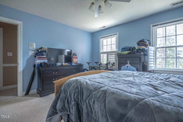 bedroom with baseboards, visible vents, a textured ceiling, and carpet