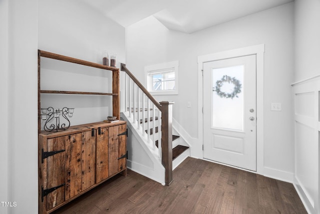 foyer entrance featuring stairway, baseboards, and wood finished floors