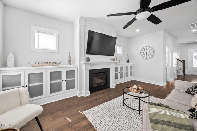 living area featuring recessed lighting, a large fireplace, baseboards, and wood finished floors