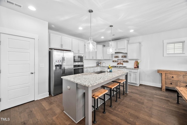 kitchen with visible vents, a sink, dark wood-style flooring, stainless steel appliances, and a kitchen island with sink