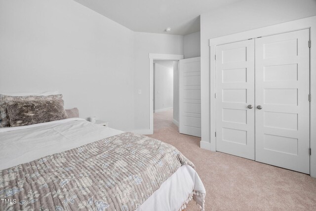 carpeted bedroom with a closet and baseboards