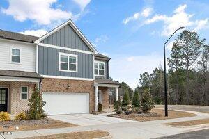 view of front of house with brick siding, board and batten siding, concrete driveway, and an attached garage