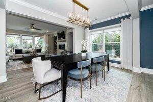 dining space featuring a wealth of natural light, baseboards, wood finished floors, and ornamental molding