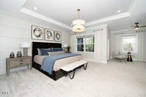 bedroom with carpet floors, a tray ceiling, and ornamental molding