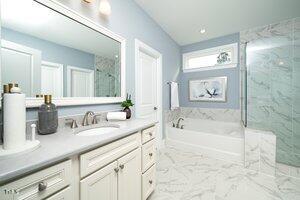 bathroom featuring a marble finish shower, marble finish floor, vanity, and a bath