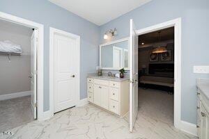 bathroom with vanity, baseboards, and marble finish floor