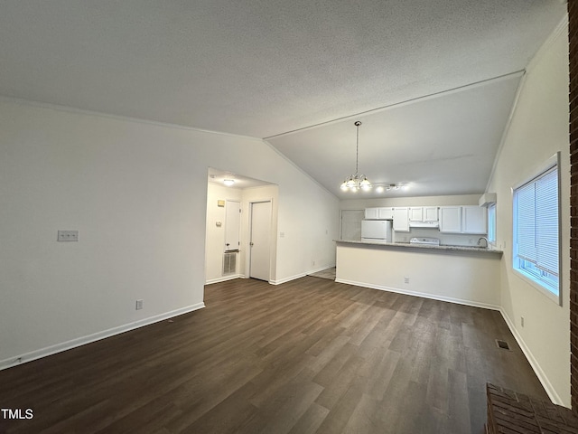 unfurnished living room with baseboards, dark wood finished floors, vaulted ceiling, a textured ceiling, and a notable chandelier