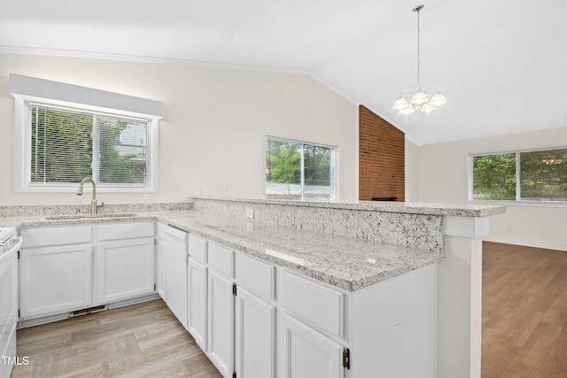 kitchen with white dishwasher, a peninsula, a chandelier, and light wood-style flooring