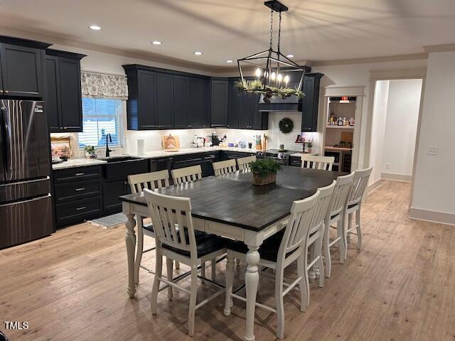 dining area with a chandelier, recessed lighting, baseboards, and light wood-style floors