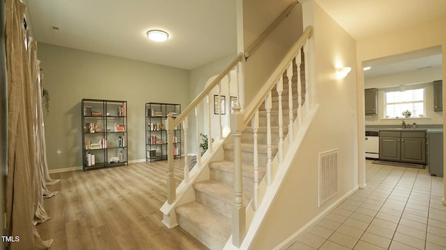 stairs featuring visible vents, baseboards, and tile patterned flooring