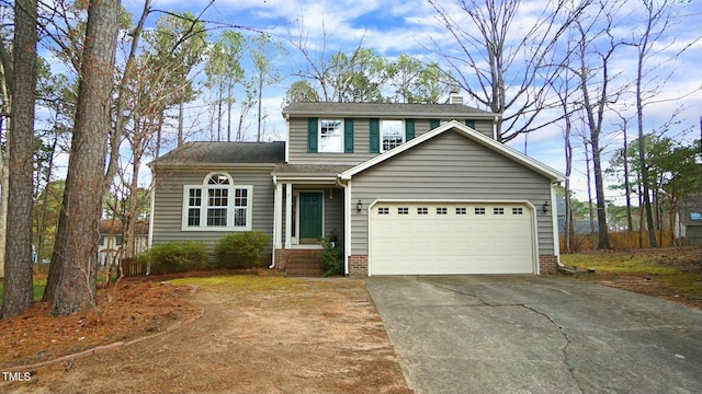 traditional-style home with a shingled roof, an attached garage, driveway, and a chimney