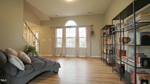 sitting room with stairway, baseboards, and wood finished floors