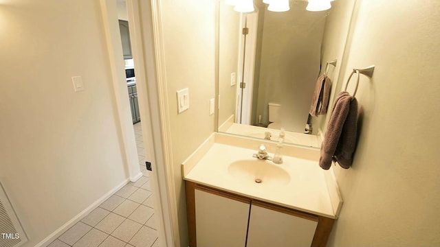 bathroom featuring tile patterned floors, baseboards, toilet, and vanity