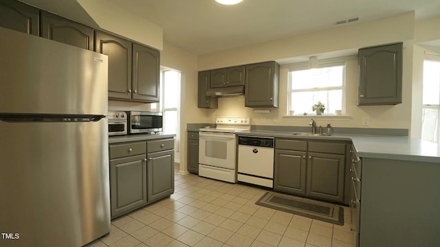 kitchen with visible vents, gray cabinets, a sink, under cabinet range hood, and appliances with stainless steel finishes