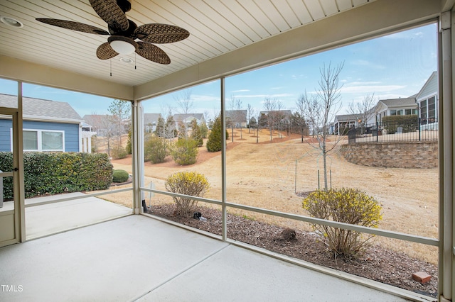 unfurnished sunroom featuring a ceiling fan